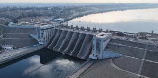 Aerial view of a large dam with water flowing through its gates