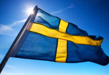Pay-to-Leave Strategy Rocks Migration Policy Swedish flag waving against a clear blue sky