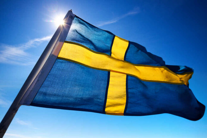 Swedish flag waving against a clear blue sky