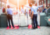 Airport security personnel assisting passengers at a checkpoint