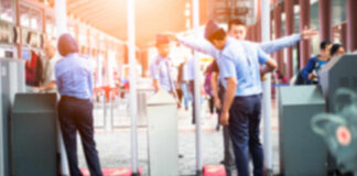 Airport security personnel assisting passengers at a checkpoint