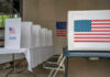 Voting booth with American flag and ballot box in a polling station