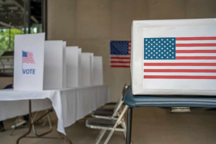 Voting booth with American flag and ballot box in a polling station