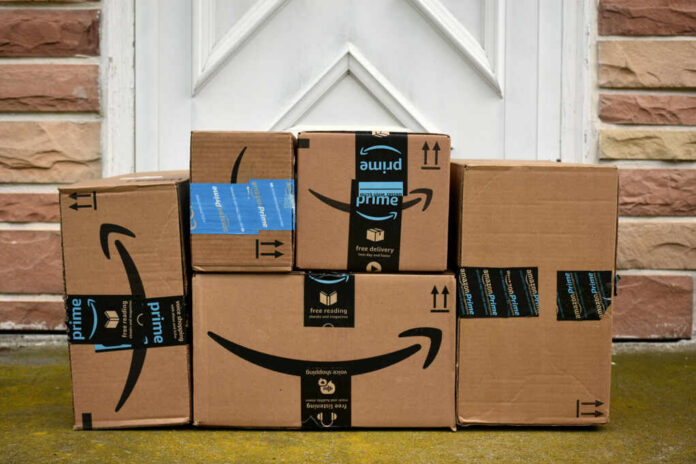 shutterstock634308593jpg Stack of Amazon delivery boxes on a front porch