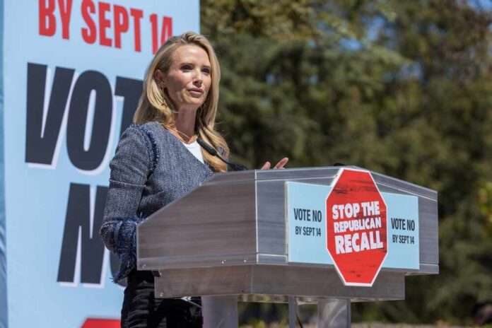 Speaker at a podium addressing a crowd at a political rally