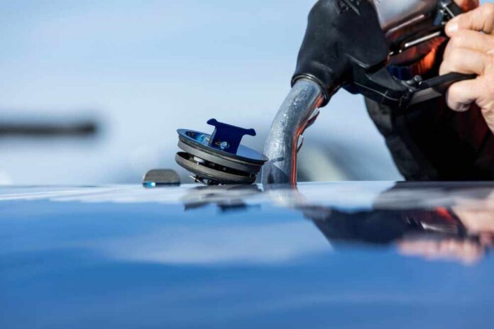 Close-up of a person refueling a vehicle at a gas station