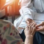 $3.5 BILLION Medicare Scheme EXPOSED In LA A doctor holding the hand of an elderly patient during a consultation