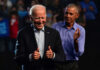 Joe Biden smiling and giving thumbs up while Barack Obama applauds in the background