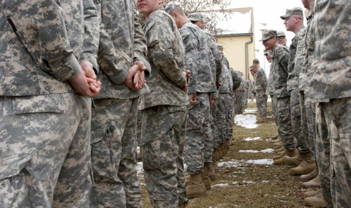 A line of soldiers in military uniforms standing outdoors in formation