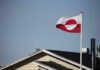 Flag of Greenland waving in the wind above a house