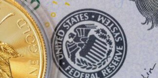 Close-up of a gold coin next to a US dollar bill