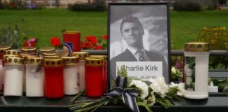Memorial setup with candles, flowers, and a framed photograph