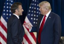 Two political leaders engaging in conversation with flags in the background