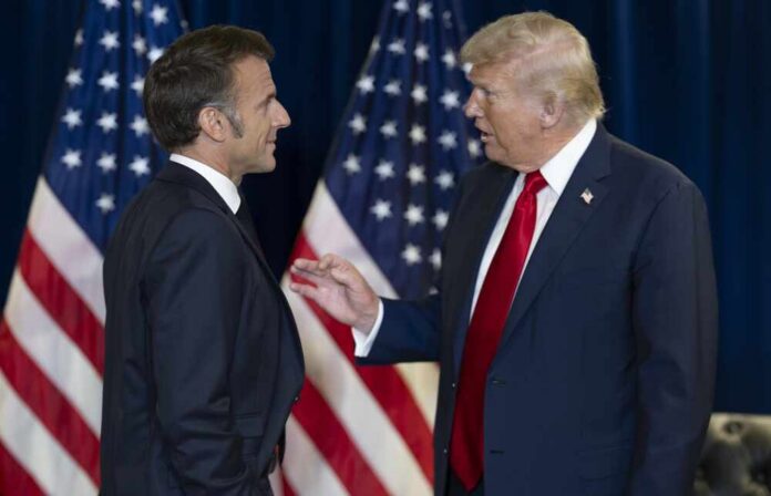 Two political leaders engaging in conversation with flags in the background