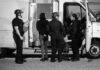 Police officers interacting with an individual near a van at night