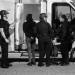 Police officers interacting with an individual near a van at night