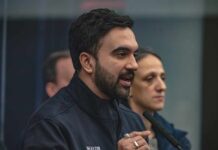 MASSIVE TAX Hike Threatens NYC’s Wealthy A man in a mayor's jacket speaking at a press conference with a woman in the background