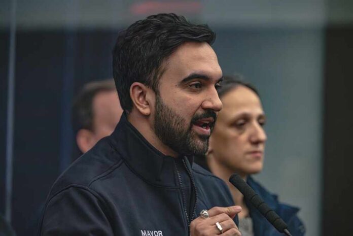 shutterstock_2729778987.jpg A man in a mayor's jacket speaking at a press conference with a woman in the background
