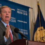 Politician speaking at a podium during a press conference
