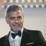 A man in a tuxedo smiling at an event