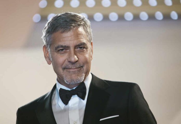A man in a tuxedo smiling at an event