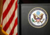 Seal of the Department of State next to an American flag