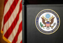 Seal of the Department of State next to an American flag