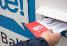 New Voting Plan Sidesteps Congress Debate Person placing a mail-in ballot into a voting drop box