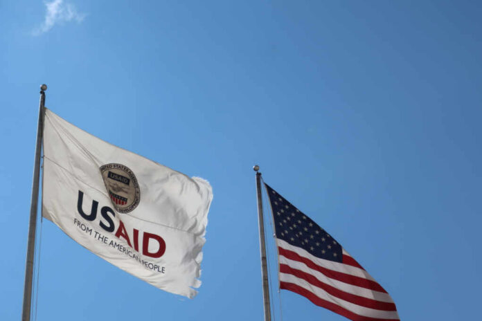 Washington,-,August,2,,2020:,Usaid,Agency,For,International,Development USAID flag and American flag waving against a clear blue sky
