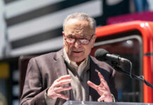Schumer’s Blunt Shutdown Remark Sparks Fury A man in a blazer speaking passionately at a podium with a microphone