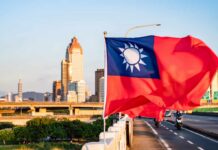 Taiwan flag waving in front of a city skyline during sunset
