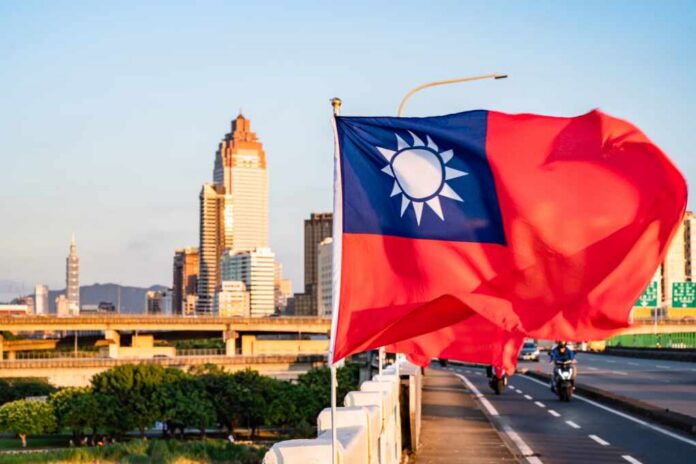Taiwan flag waving in front of a city skyline during sunset