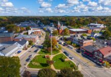 Aerial view of a small town square with park and flagpole
