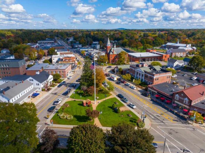Aerial view of a small town square with park and flagpole
