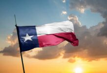 Prison Camp Plan BACKFIRES: Dem Defeated! Texas flag waving against a sunset backdrop with clouds