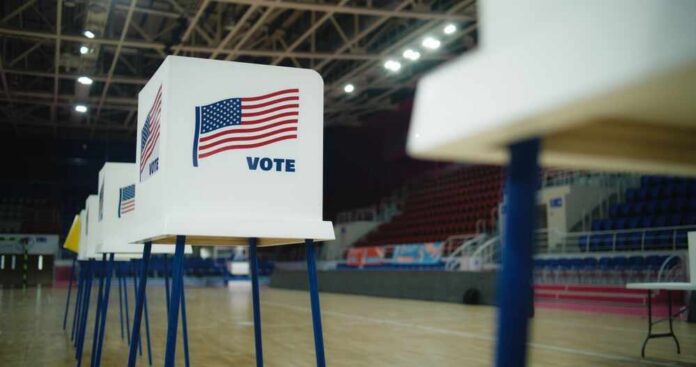 National,Election,Day,In,The,United,States,Of,America.,Voting Voting booths with American flags set up in a gymnasium