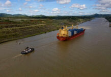 Global Crisis: Strait of Hormuz’s Unresolved Turmoil A cargo ship being assisted by a tugboat in a canal