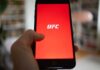 White House Turns Into UFC Fight Arena Hand holding smartphone with red app screen