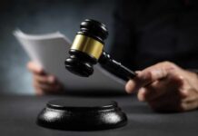 Unbelievable Verdict: Evidence Tossed! A gavel held above a sounding block with a person reading documents in the background