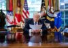 A political leader reading documents in the Oval Office