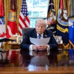 A political leader reading documents in the Oval Office