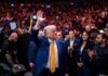 Trump’s Iran Strike HALTED – Two Weeks of Tension! A man in a blue suit with a yellow tie waves to a cheering crowd