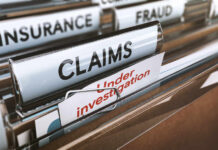 Folders labeled with insurance terms, highlighting a claim under investigation