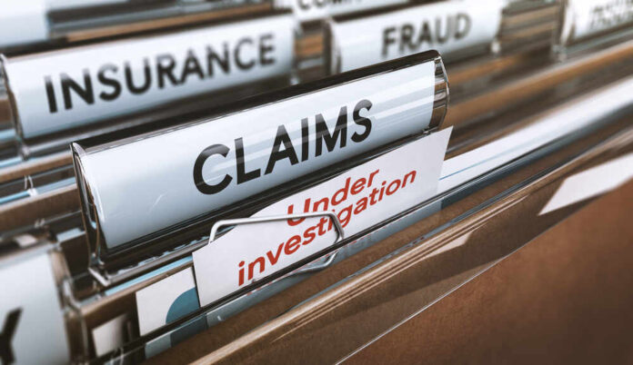 Folders labeled with insurance terms, highlighting a claim under investigation