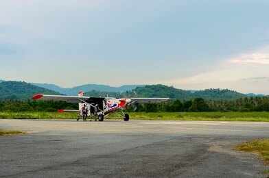 1490088875 Small propeller plane on rural runway with hills in the background