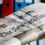 Culture War Erupts Over Father’s Day Comic Newspaper held in hand with office binders in the background