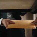 Six-Figure Bribes Rock NYC Government Hands passing a manila envelope under a table