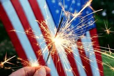 Sparkler held in front of an American flag