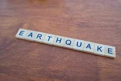 2604904905 Scrabble tiles spelling earthquake on a wooden table