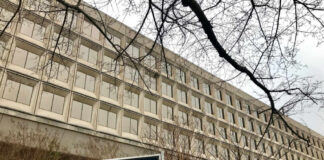 Exterior view of the Department of Energy building with a sign and surrounding trees